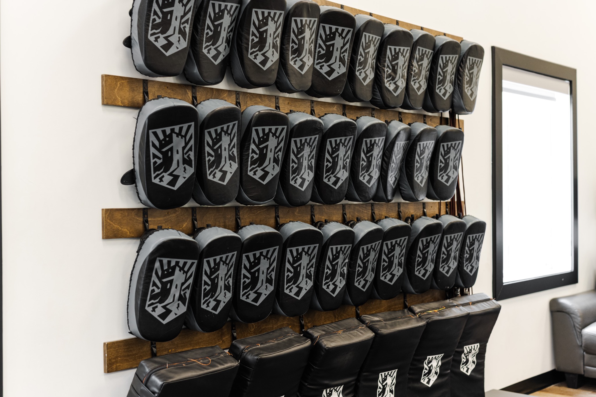 Fort-branded kickboxing pads arranged on the gym wall