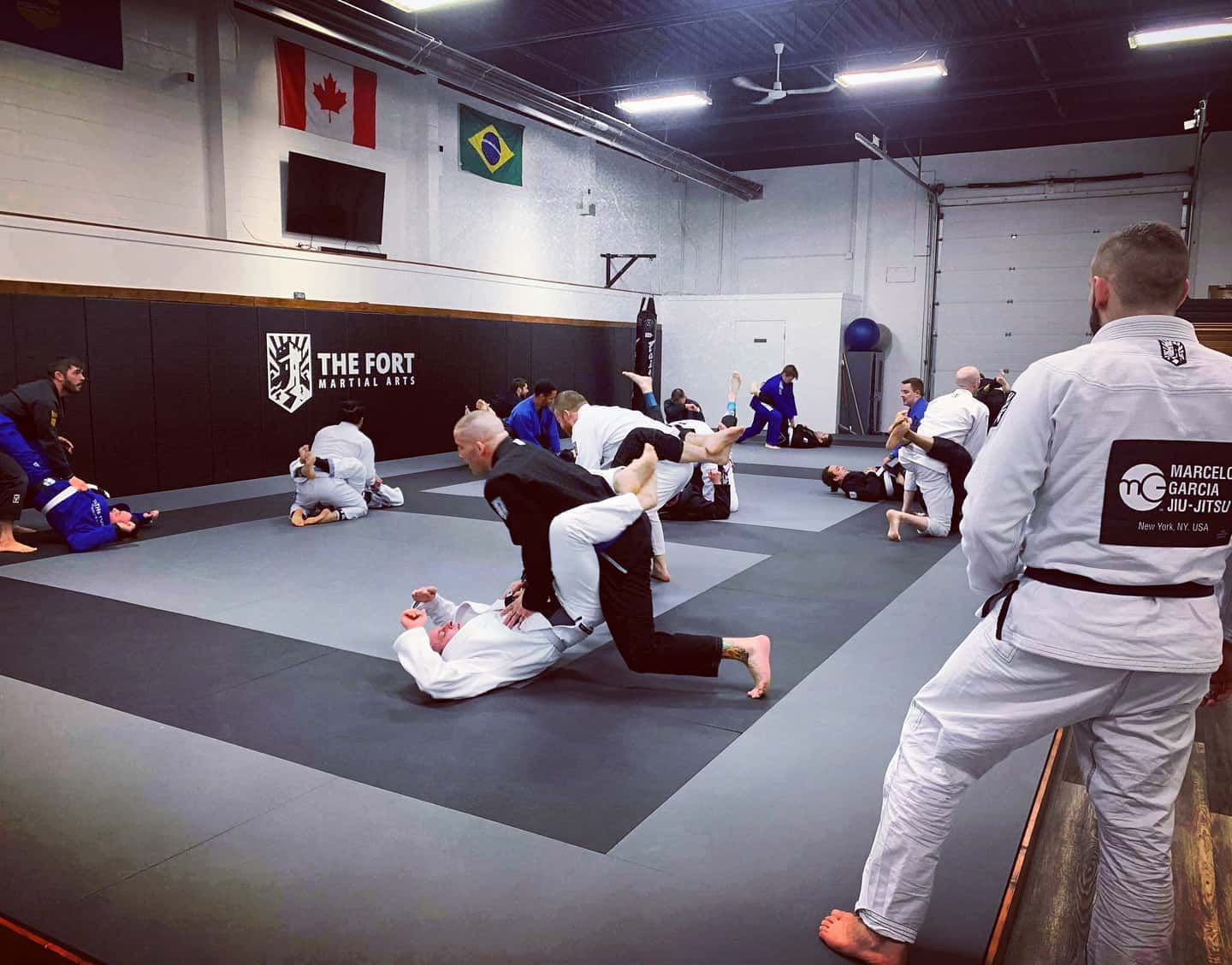 Fort members practising Jiu-Jitsu together in pairs during a class