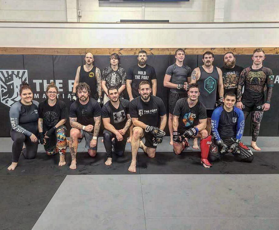 Tanner Boser with Fort students and coaches on the academy mats