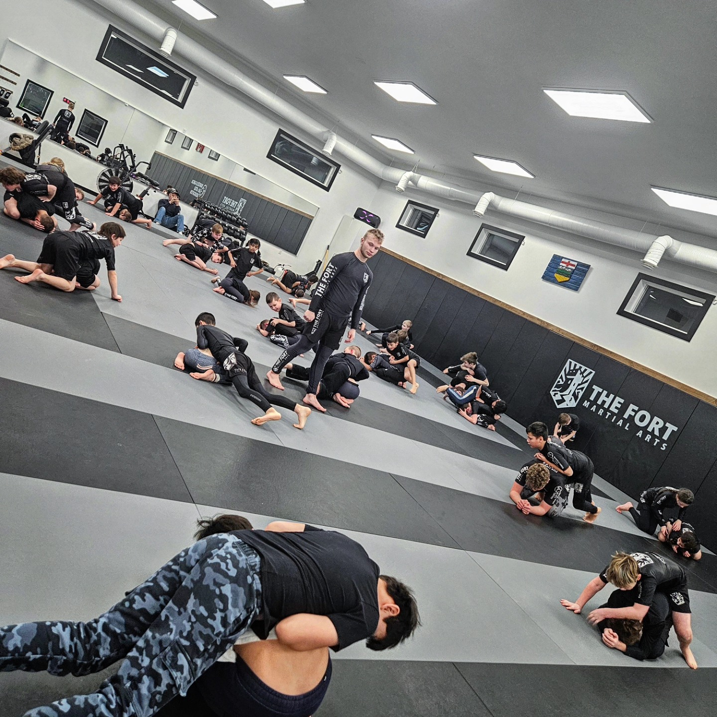 Young Fort members practicing grappling with a coach supervising